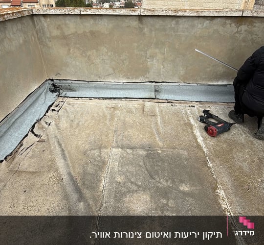 גג עם עבודת איטום וכלי עבודה
